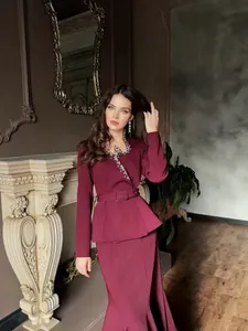 Elegant burgundy two-piece suit set with rhinestone V-neck blazer and long skirt.