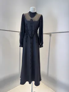 Detailed view of elegant French black maxi dress with mesh sleeves and lace floral accents
