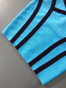 Gros plan du tissu d'une robe bandage bleue avec des rayures violettes contrastantes.