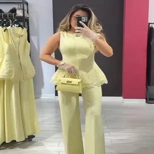 Yellow two-piece set featuring a sleeveless lace-hem peplum top and matching wide-leg pants.