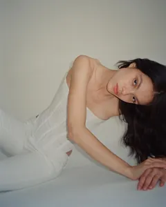 Fashion model wearing a white high-stretch mesh corset tube top in a studio setting