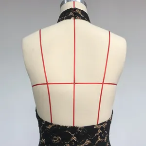 Detailed macro view showing the back lace texture of a black halter neck dress.