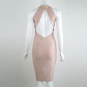 Vista posteriore di un vestito a bende color rosa nudo con pesanti decorazioni borchiate