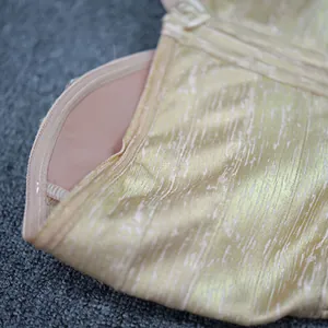 Close-up of the luxurious gold metallic fabric and built-in bra cup of evening dress.