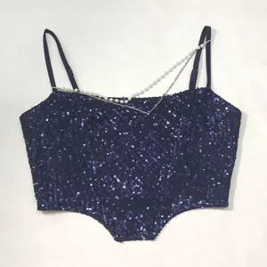 Detail of a navy blue sequined camisole with pearl and silver chain decorations.