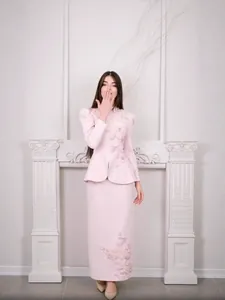 Ensemble élégant rose deux pièces avec broderie papillon texturée et jupe longue.