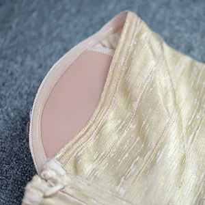 Close-up detail of luxury gold foil evening dress showing built-in chest pad and fabric texture