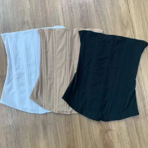 High-stretch mesh corset tube tops shown in white, beige, and black on a wooden floor