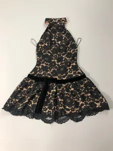Detail of black lace halter mini dress featuring a velvet bow and eyelash lace hem