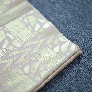 Detailed view of luxury gold foil geometric pattern on pink bandage evening dress