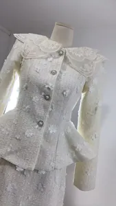 Detailansicht einer eleganten weißen Tweedjacke mit 3D-Blumenapplikationen und Perlen