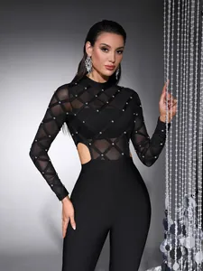 Detail of black mesh long sleeve jumpsuit with handmade pearls and waist cutouts.