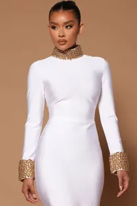 Detail of elegant white bandage dress with intricate gold beaded collar and cuffs