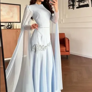 Detail van een elegante lichtblauwe avondjurk met kralen taille en lange cape-mouwen