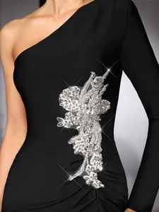 Close-up detail of the elegant floral rhinestone applique on a black one-shoulder dress