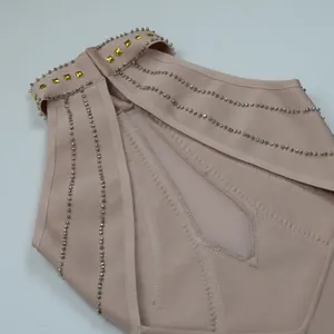 Dettaglio del ricamo pesante con perline sull'abito bandage rosa con scollo halter