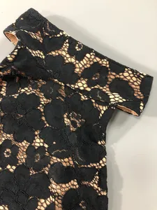 Close-up of black floral lace fabric on a sexy mini dress with nude lining