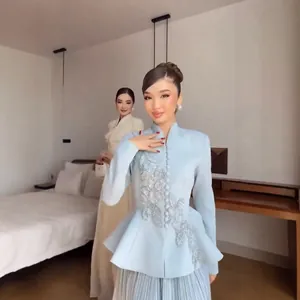 Full-length view of elegant light blue embroidered blazer and pleated skirt set.