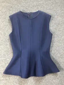 Detailed view of a navy blue sleeveless bandage top with a stylish peplum hem design