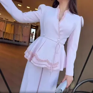 Vue détaillée d'un ensemble peplum élégant à manches longues avec perles et pantalon