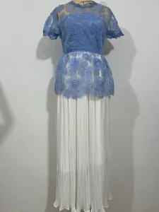 Detailed view of light blue lace floral top with pearls and white pleated skirt