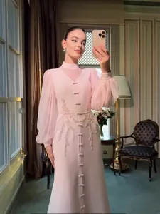 Elegante vestido largo francés rosa con mangas de malla y bordados florales de encaje.