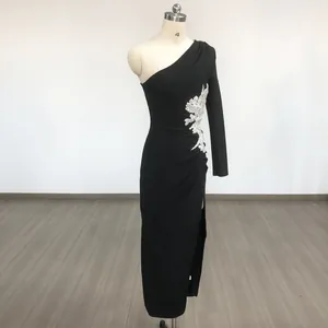 Black one-shoulder long-sleeve evening gown with silver rhinestone flower and high leg slit