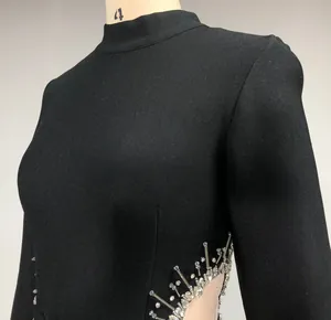 Detailed view of black long sleeve bandage dress with shimmering rhinestone waist design