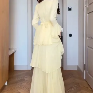 Elegant pale yellow tiered maxi dress showing tiered ruffled back and bow tie detail