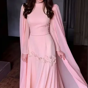 Detailweergave van roze avondjurk met elegante cape-mouwen en bloemenborduursel