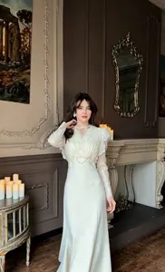 Elegant lace long sleeve mermaid gown with high waist design in luxury setting