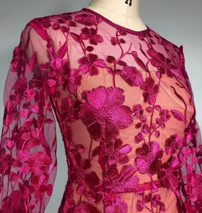 Detailed close-up of an elegant fuchsia dress with 3D floral embroidery and lace