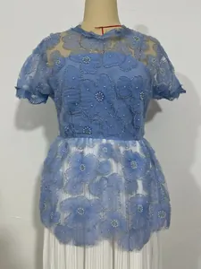 Detailed view of blue floral lace dress with elegant pearl bead accents on mannequin