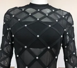 Close-up of sexy black mesh bodysuit with silver studs and criss-cross bandage details