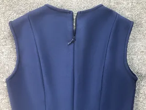 Close-up of the back hidden zipper on this navy blue sleeveless bandage top.