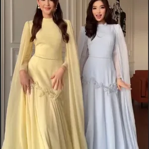 Elegant detail van een avondjurk met geborduurde taille en vloeiende cape-mouwen