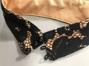Detailed macro view of black eyelash lace halter neck collar with button closure