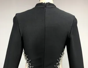 Detailed back view of a black bandage evening dress with rhinestone side cutouts