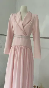 Vue complète d'une robe longue rose à col en V et détails perlés sur mannequin de couture.