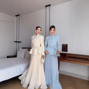 Full view of elegant embroidered jacket and pleated skirt set in cream and light blue.