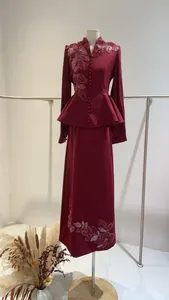 Detail view of burgundy peplum blazer and maxi skirt set with elegant floral embroidery