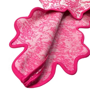 Close-up of rose red jacquard bandage fabric with unique scalloped edge design.