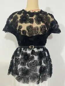 Close-up of black lace floral appliqué with bead detailing and elegant gold buckle belt