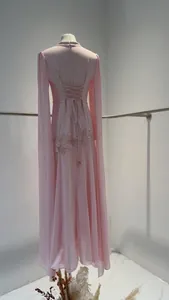 Achterkant detail van een elegante roze avondjurk met kralenborduursel en cape mouwen