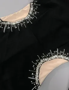 Close-up of intricate rhinestone and beadwork on a black mesh evening dress