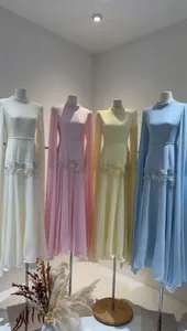 Gedetailleerde weergave van vier elegante avondjurken met cape-mouwen en borduursels