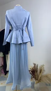 Back view of elegant light blue blazer with lace-up detail and pleated maxi skirt set