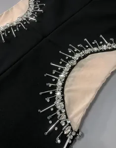 Close-up of sparkling rhinestone and bead embellishments on black mesh bandage dress