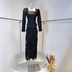 Detailed view of black maxi dress with heavy floral lace embroidery on mannequin