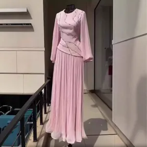 Close-up detail of the intricate pleats and sparkling rhinestone patterns on the pink dress.